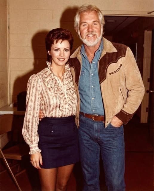 Leyenda de la música country posa con su esposa actriz: ¡pero los fans no dejan de mirar a la estrella pop de los años 80 que los acompaña!